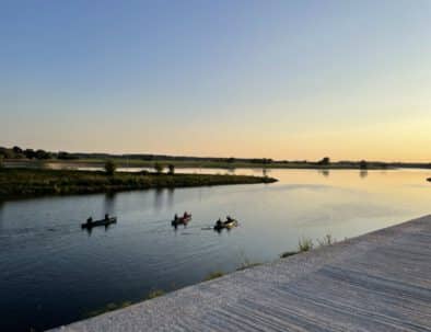 Drei Kanus auf der Stepenitz kurz vor der Mündung in die Elbe; ruhiges Wasser, weite Flusslandschaft und warmes Abendlicht – nahe den Elbe.6-Apartments.