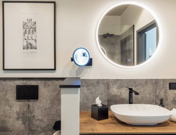 Eleganter Waschtisch mit beleuchtetem Spiegel und Kosmetikspiegel des ELBE.6 Apartment I.