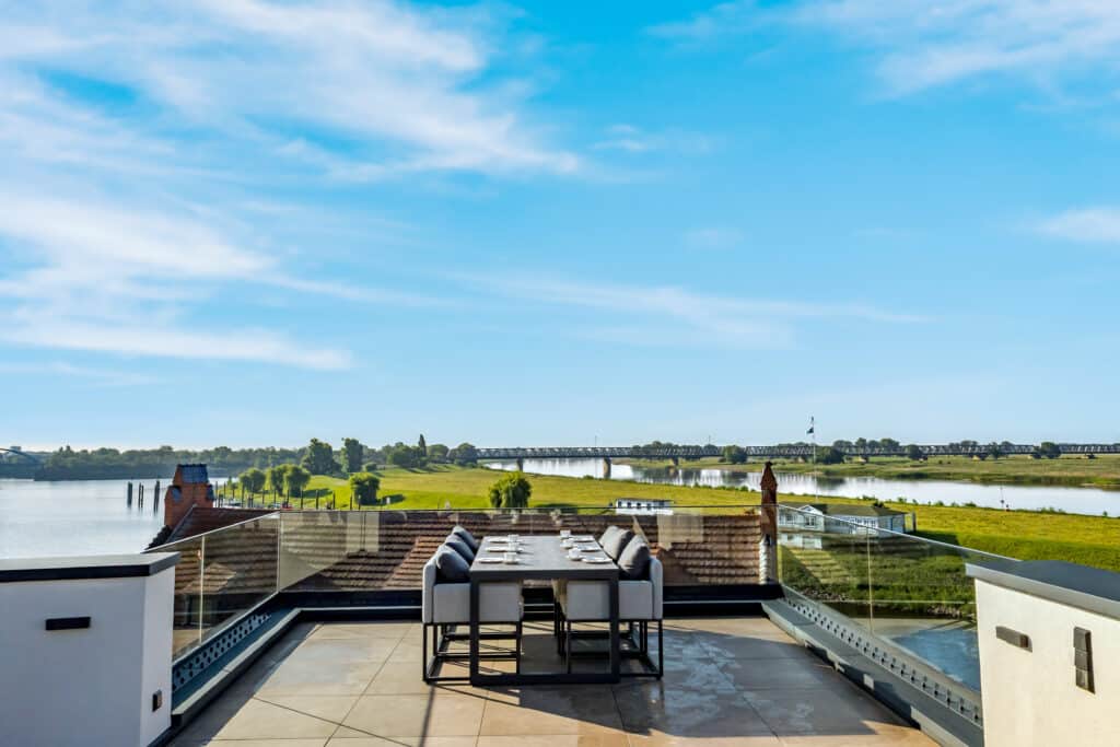 Große Dachterrasse mit Esstisch und Blick über die Elbe und die Elbbrücke im ELBE.6 Apartment II in Wittenberge.