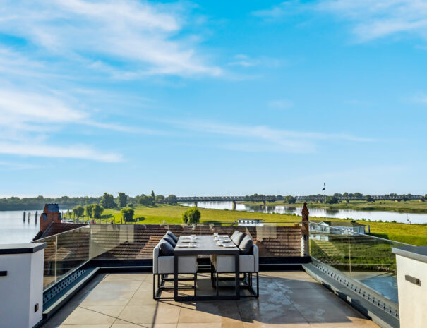 Große Dachterrasse mit Esstisch und Blick über die Elbe und die Elbbrücke im ELBE.6 Apartment II in Wittenberge.