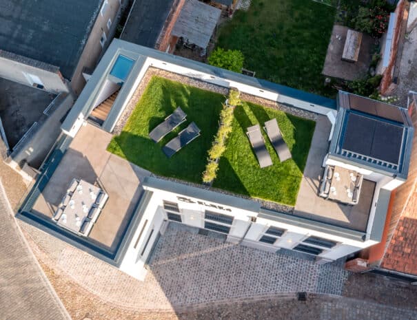 Luftaufnahme des Dachgartens der ELBE.6 Apartments in Wittenberge mit Photovoltaikanlage, begrüntem Bereich und Terrasse – nachhaltiges Energiekonzept mit Wärmepumpe.