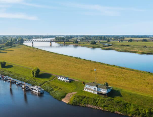 Luftaufnahme der Elbwiesen bei Wittenberge mit Elbdeich, Bootsanlegern und Brücke über die Elbe – nahe der ELBE.6 Apartments.