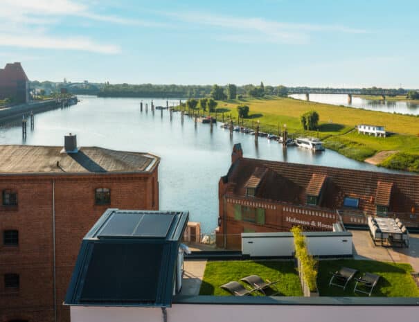 Panoramablick von den ELBE.6 Apartments über die Elbe, das historische Kranhaus und die Elbwiesen in Wittenberge.