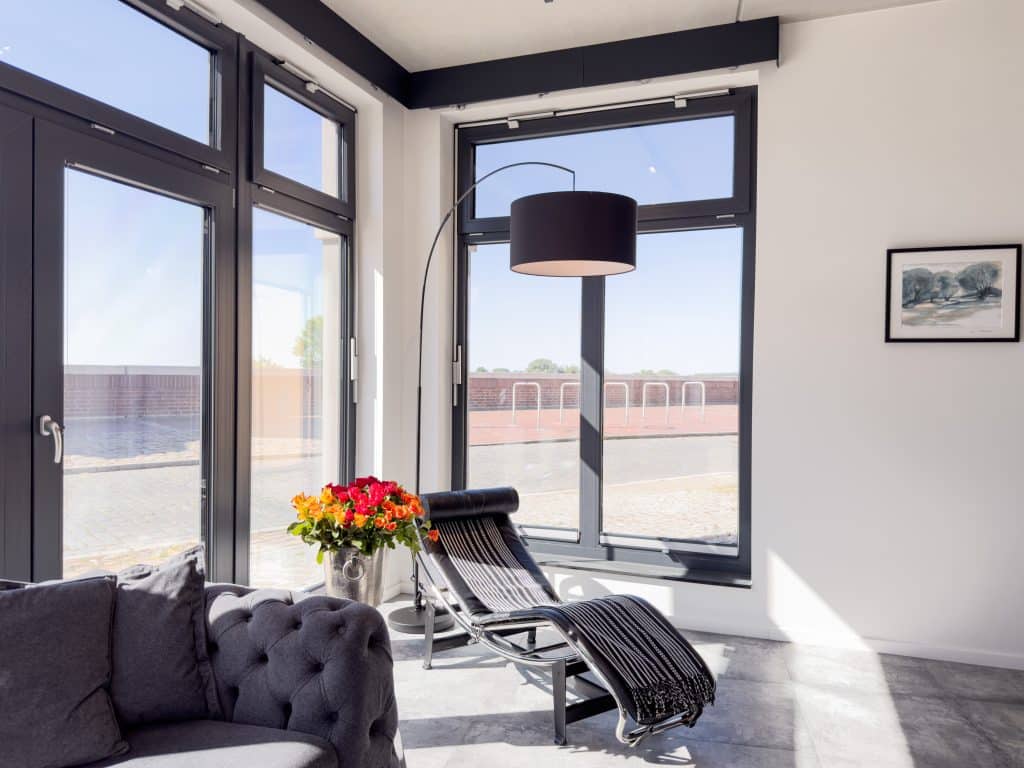 Helles Wohnzimmer mit großer Fensterfront im ELBE.6 Apartment I in Wittenberge