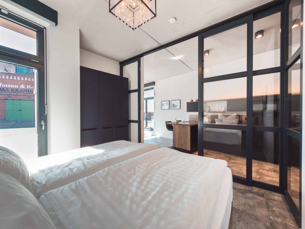 Schlafzimmer mit moderner Glaswand im ELBE.6 Apartment I in Wittenberge
