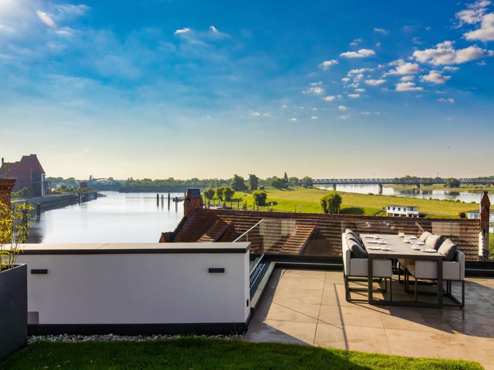 Große Dachterrasse mit Esstisch und Blick auf die Elbe im ELBE.6 Apartment II in Wittenberge.