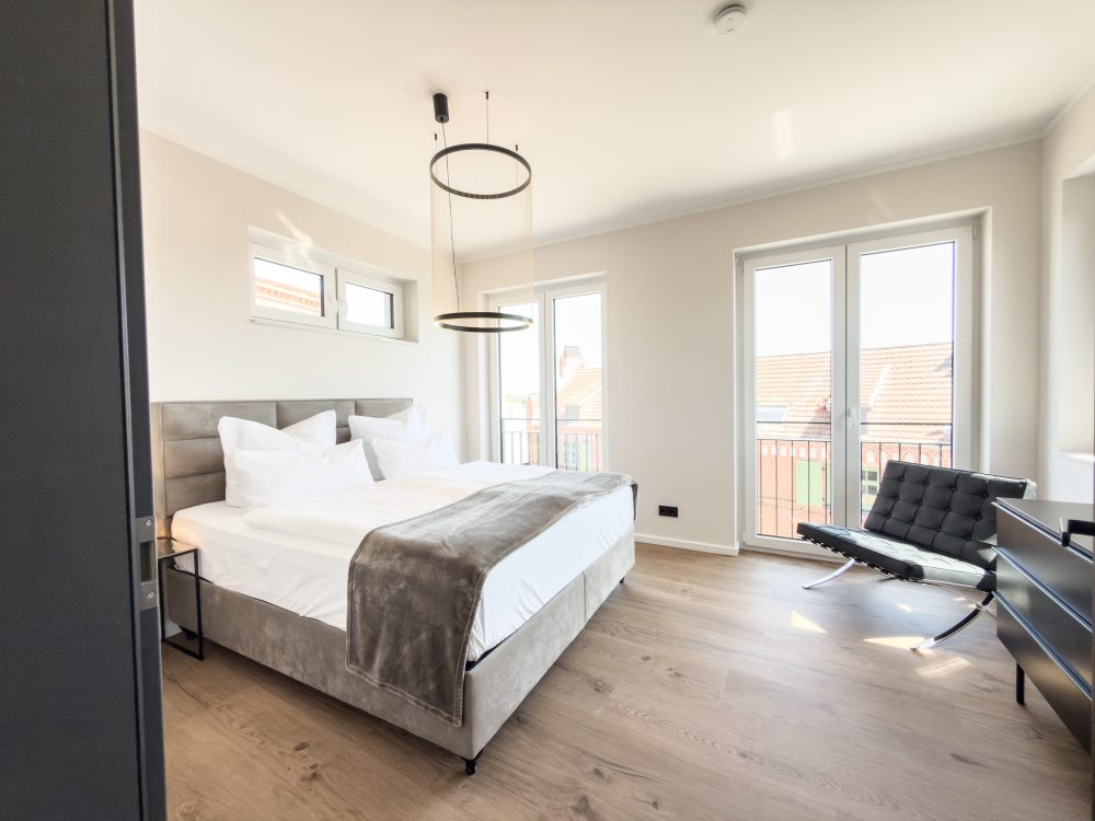 Schlafzimmer mit Zugang zum Balkon im ELBE.6 Apartment II in Wittenberge