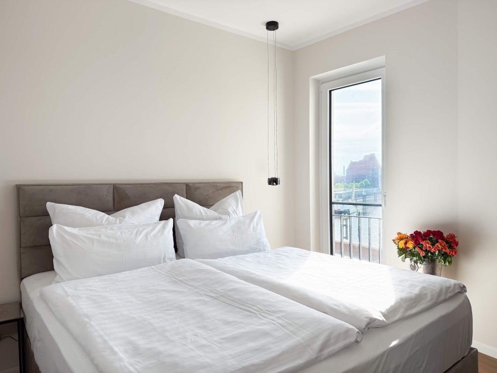 Dritte Ansicht des Schlafzimmers mit Doppelbett im ELBE.6 Apartment II in Wittenberge
