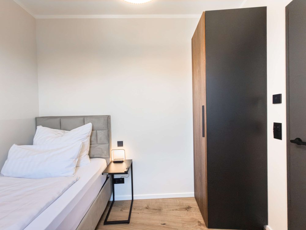 Weitere Ansicht des Schlafzimmers mit Einzelbett im ELBE.6 Apartment II in Wittenberge