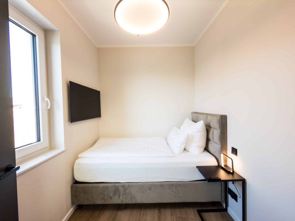 Schlafzimmer mit Einzelbett im ELBE.6 Apartment II in Wittenberge