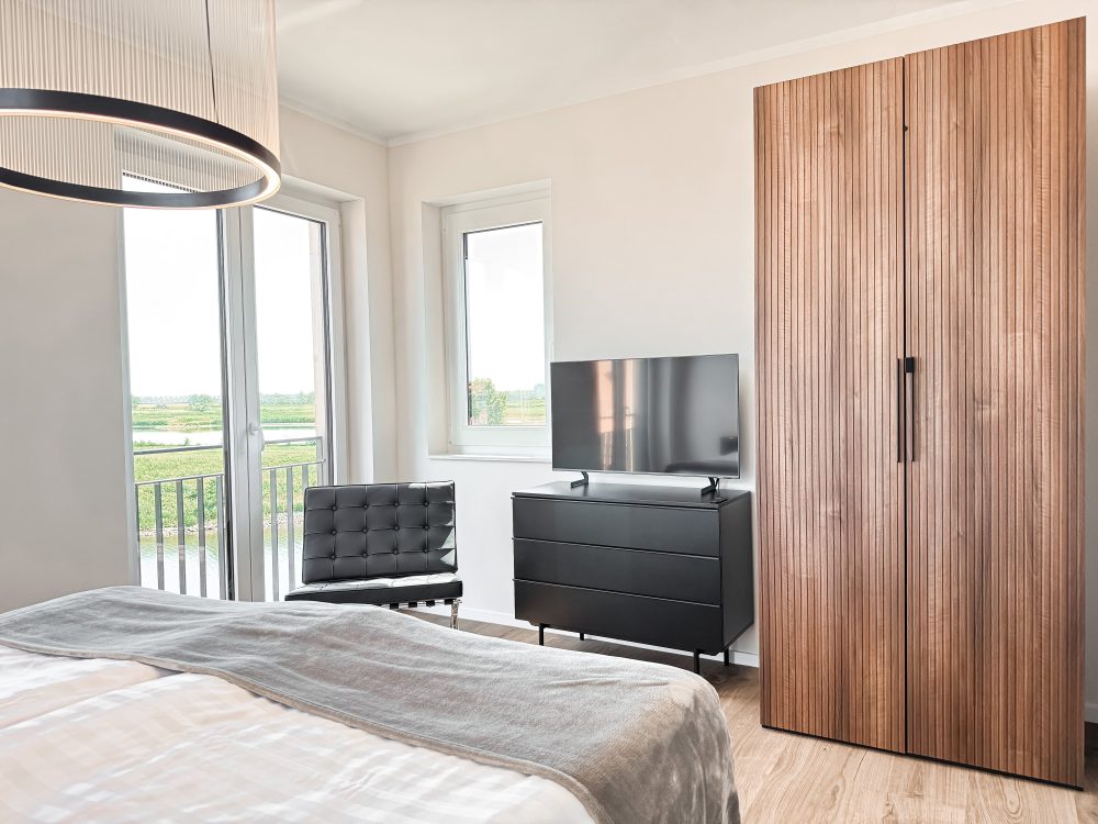Schlafzimmer mit Kleiderschrank im ELBE.6 Apartment II in Wittenberge